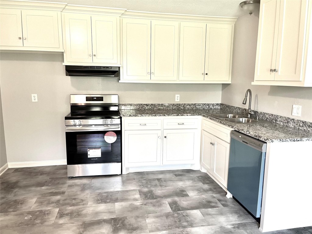 104 Peach Street Tomball, TX 77375 - Photo 5 of 19 a kitchen with stainless steel appliances granite countertop a stove a sink and a microwave