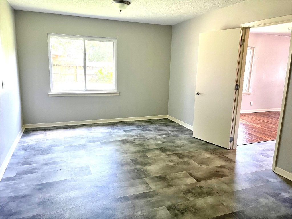 104 Peach Street Tomball, TX 77375 - Photo 8 of 19 a view of an empty room with wooden floor and a window