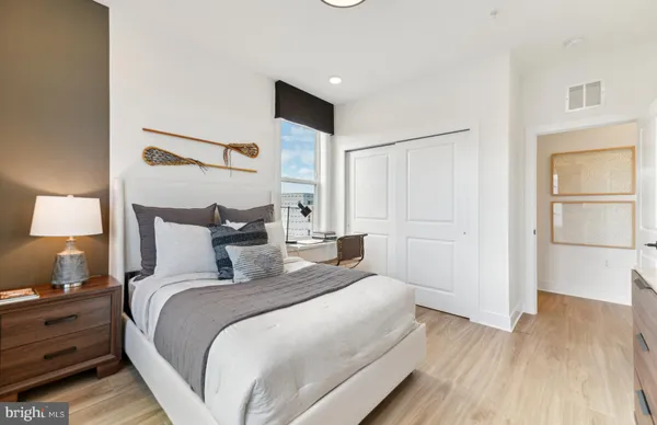 a bedroom with a bed lamps and a large window