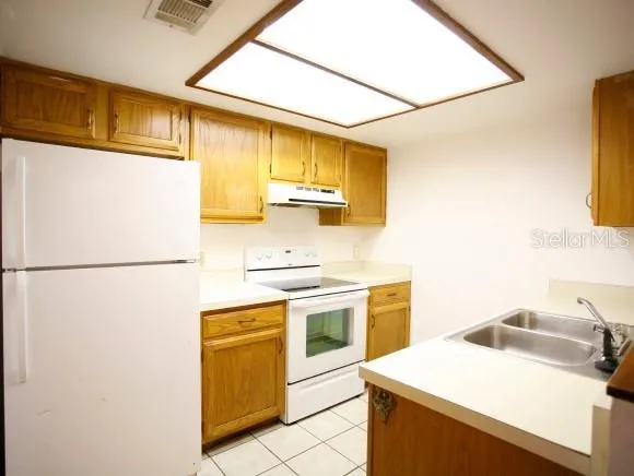 a kitchen with a sink a stove and refrigerator