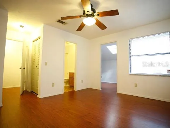 a view of an empty room with window and wooden floor