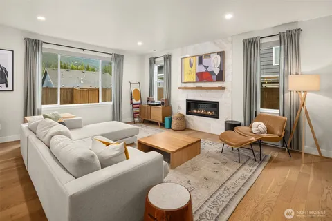 a living room with furniture a fireplace and a large window