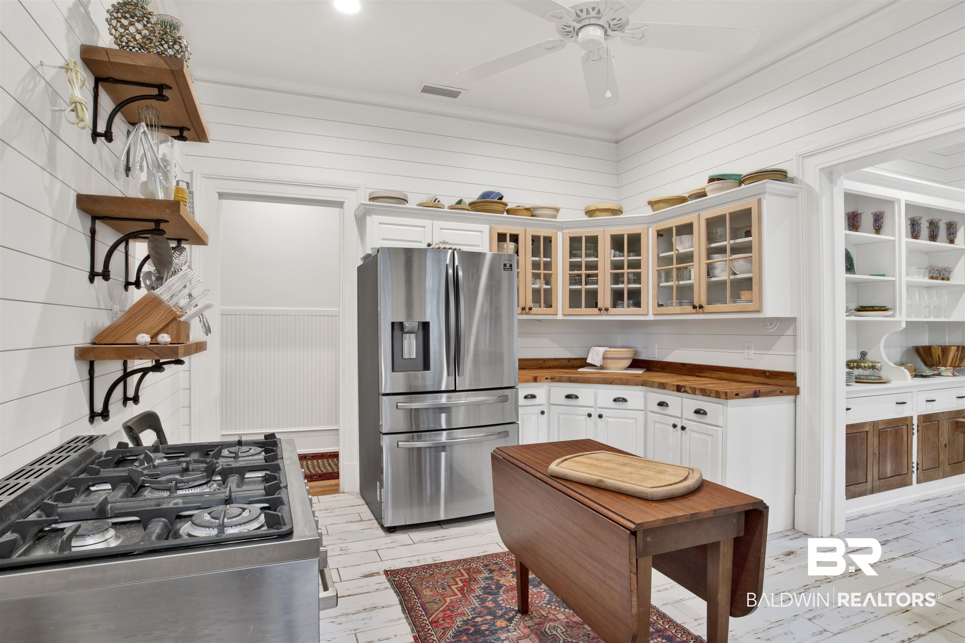 1654 Government Street Mobile, AL 36604 - Photo 27 of 45 Kitchen with stainless steel fridge with ice dispenser, light wood-type flooring, white cabinets, backsplash, and ceiling fan