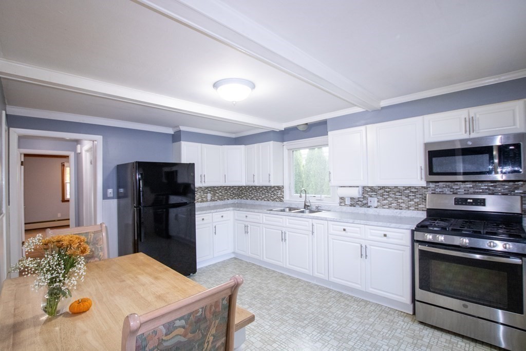 146 Davis Street Springfield, MA 01104 - Photo 8 of 15 a kitchen with stainless steel appliances kitchen island granite countertop a refrigerator stove and sink