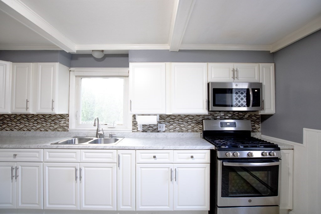 146 Davis Street Springfield, MA 01104 - Photo 9 of 15 a kitchen with stainless steel appliances granite countertop a sink stove and microwave
