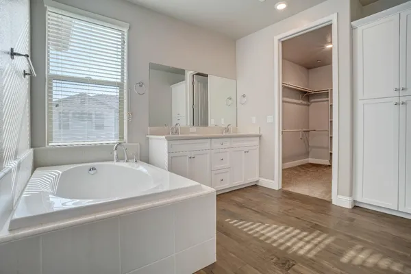 a bathroom with a double vanity sink a toilet and a large mirror