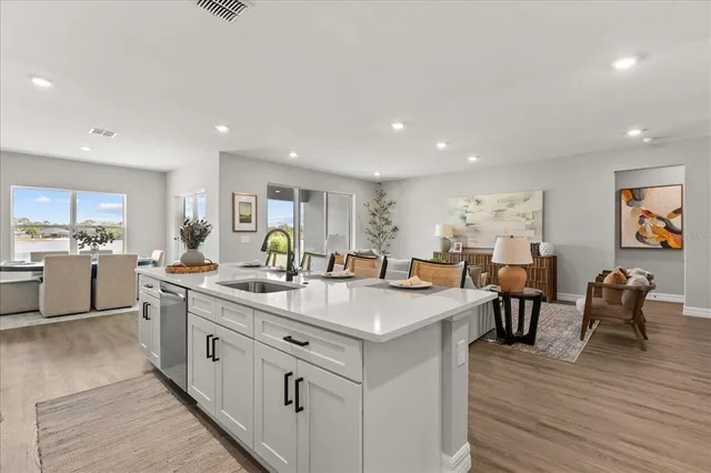 a large kitchen with kitchen island a sink table and chairs