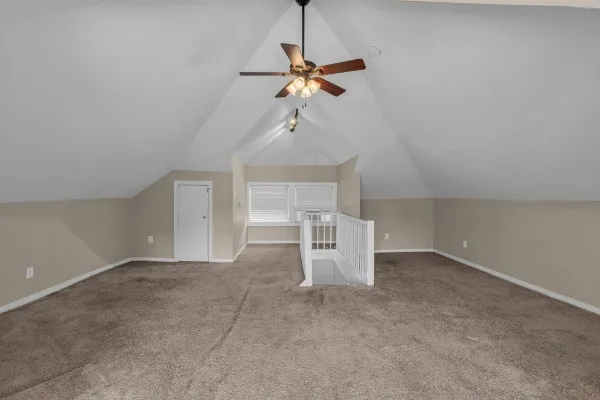 a view of a room with a ceiling fan and window