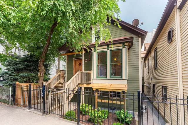 a view of a house with a large windows stairs and a large tree
