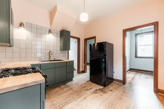 a kitchen with a refrigerator and a stove top oven