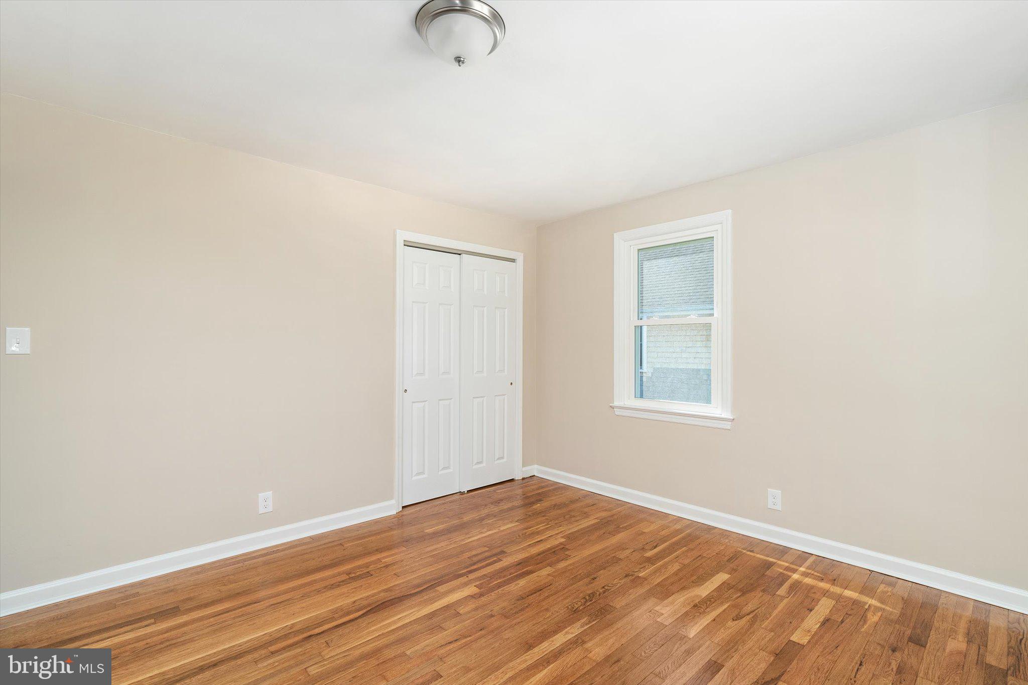 40 Unwin Drive Hamilton, NJ 08610 - Photo 13 of 26 a view of an empty room with wooden floor and a window