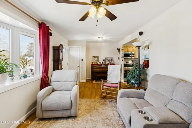 a living room with furniture a chandelier and a dining table