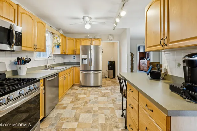 a kitchen with stainless steel appliances granite countertop a sink a stove and a refrigerator