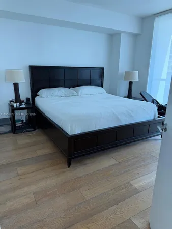 a large bed sitting in a bedroom next to a lamp