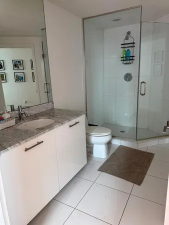 a bathroom with a granite countertop sink a toilet and shower