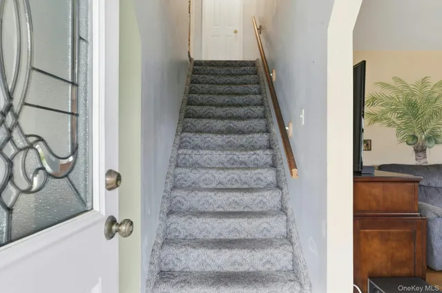 a view of staircase with white walls and railing