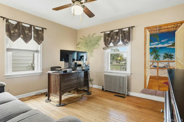 a view of a workspace with furniture and a window