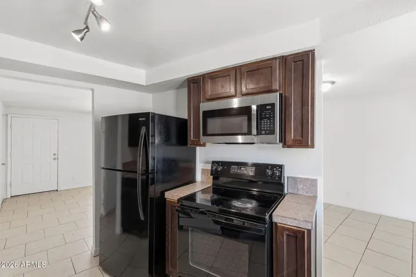 a kitchen with granite countertop stainless steel appliances a sink stove and cabinets