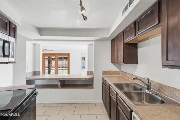 a kitchen with granite countertop a refrigerator and a stove top oven