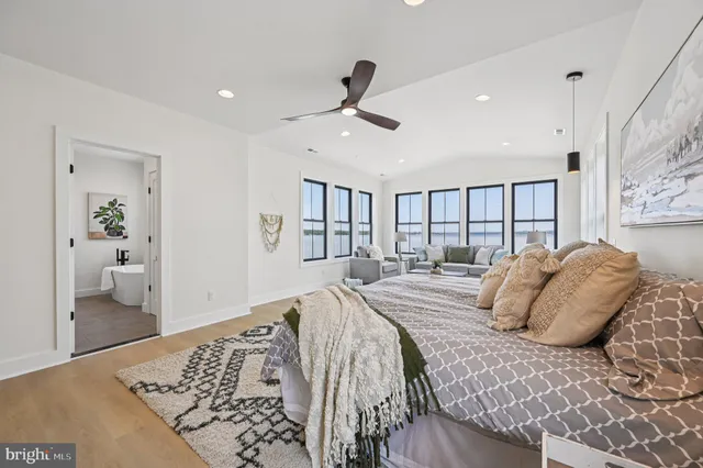 a view of an empty room with wooden floor and windows