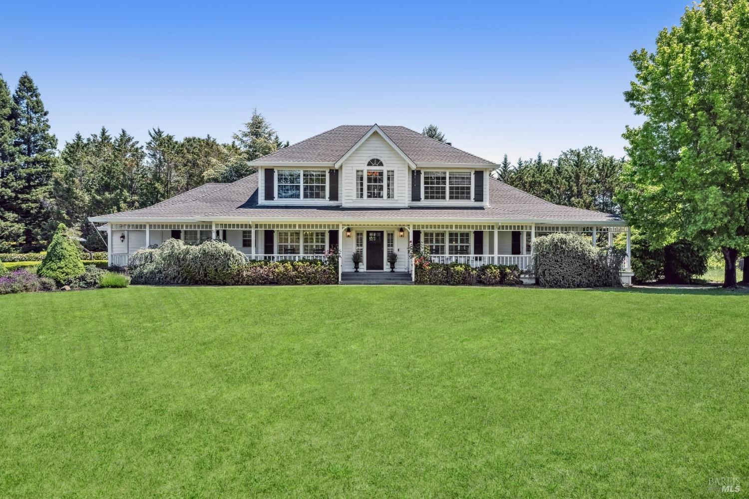 a front view of a house with a yard and trees