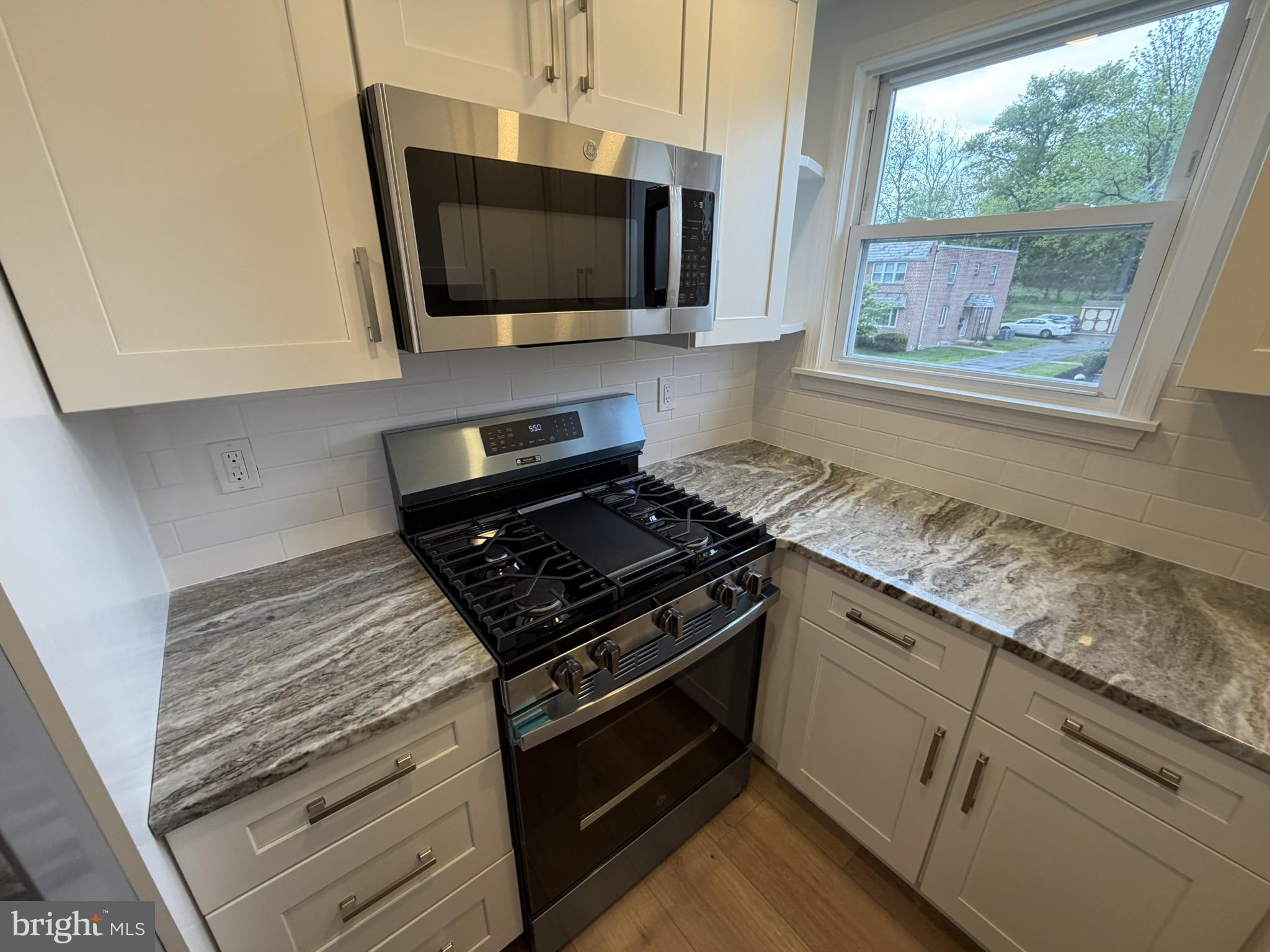 22 Windsor Road, Unit 2 Glenside, PA 19038 - Photo 14 of 29 a kitchen with stainless steel appliances granite countertop a stove and a microwave