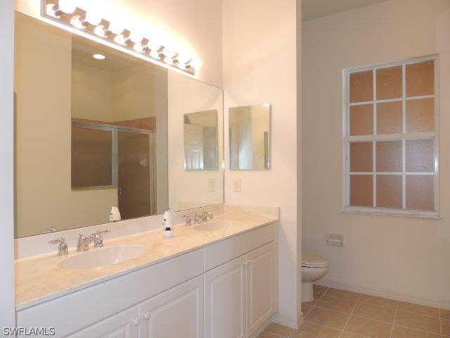 3590 Lansing Loop, Unit 201 Estero, FL 33928 - Photo 11 of 16 a bathroom with a double vanity sink mirror and toilet