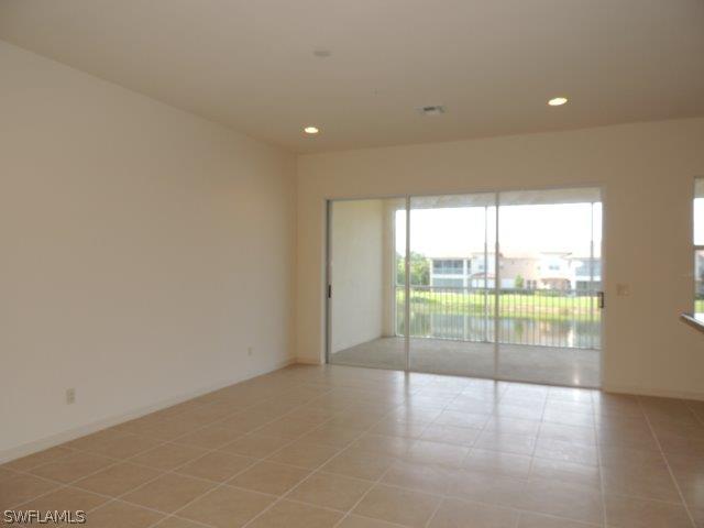 3590 Lansing Loop, Unit 201 Estero, FL 33928 - Photo 4 of 16 a view of an empty room with wooden floor and a sliding door