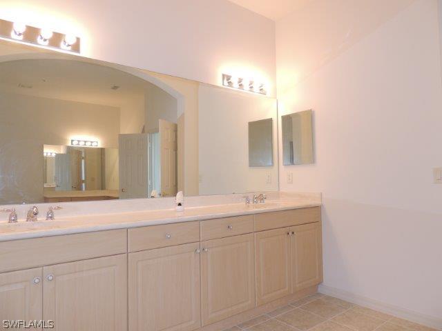 3590 Lansing Loop, Unit 201 Estero, FL 33928 - Photo 8 of 16 a bathroom with a double vanity sink and mirror