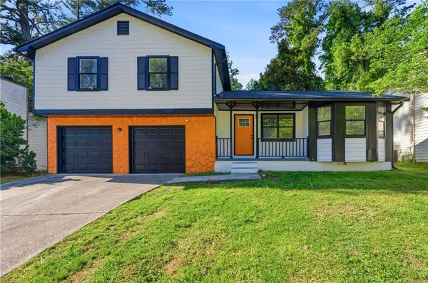 a front view of a house with a yard and garden