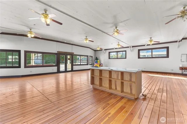 a view of an empty room with window and wooden floor