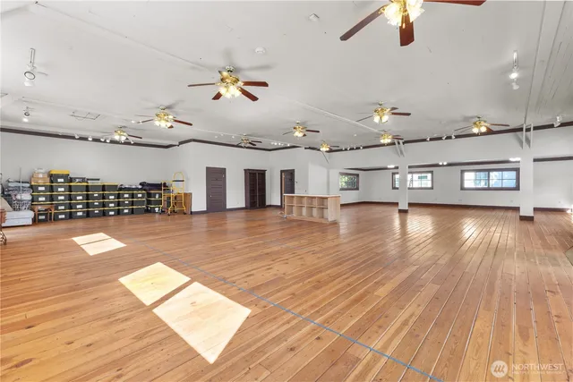 a view of a room gym equipment and wooden floor