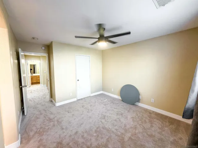 a view of a room with a ceiling fan and bathroom