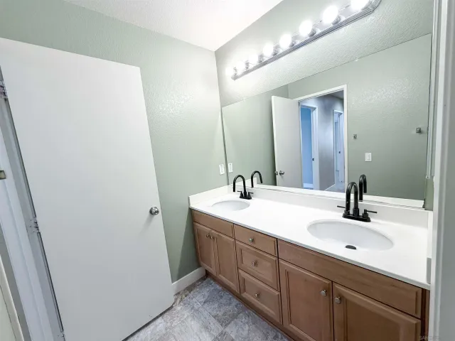 a bathroom with a double vanity sink and mirror
