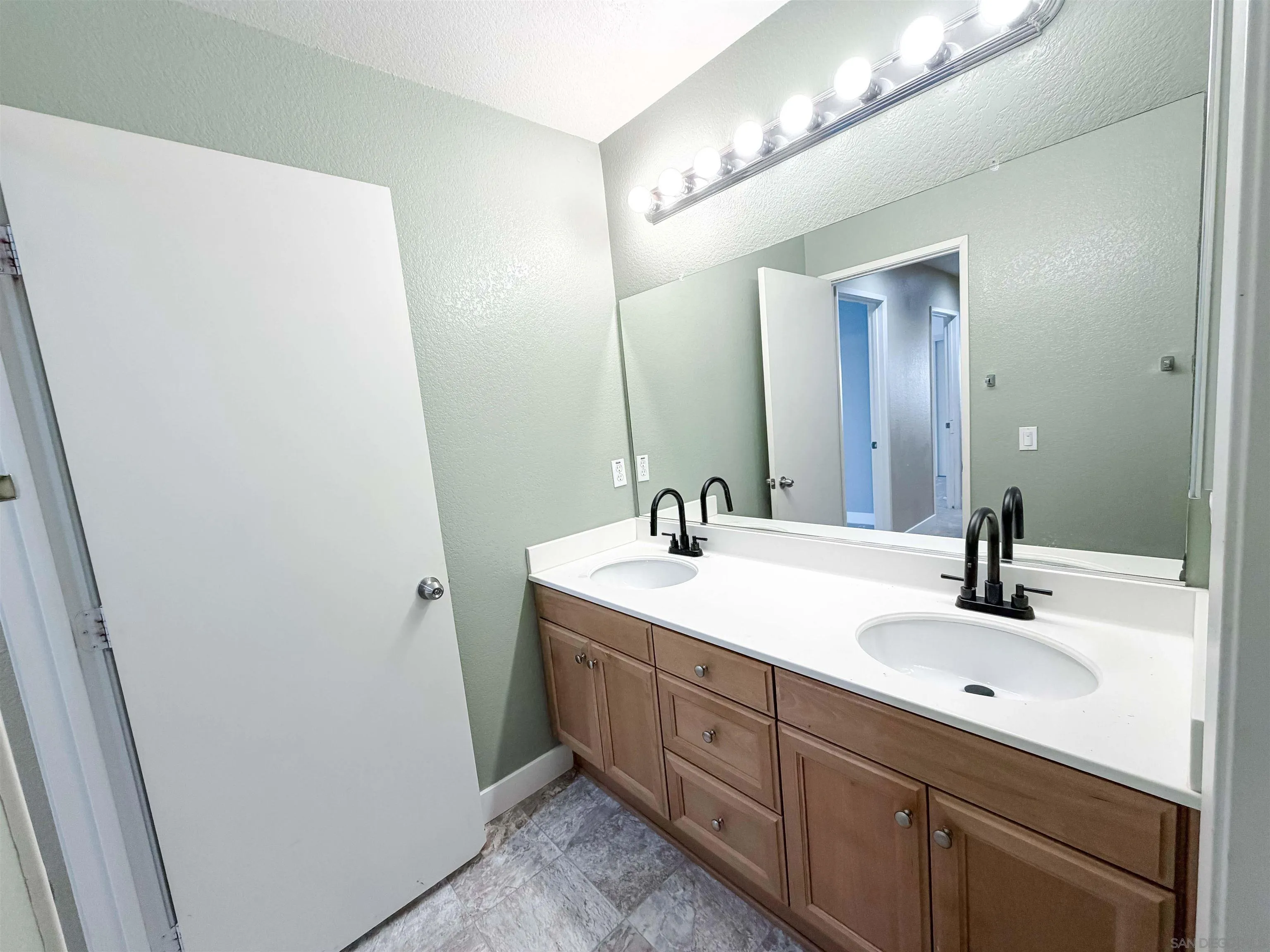 1431 Trouville Lane, Unit 5 Chula Vista, CA 91913 - Photo 23 of 28 a bathroom with a double vanity sink and mirror