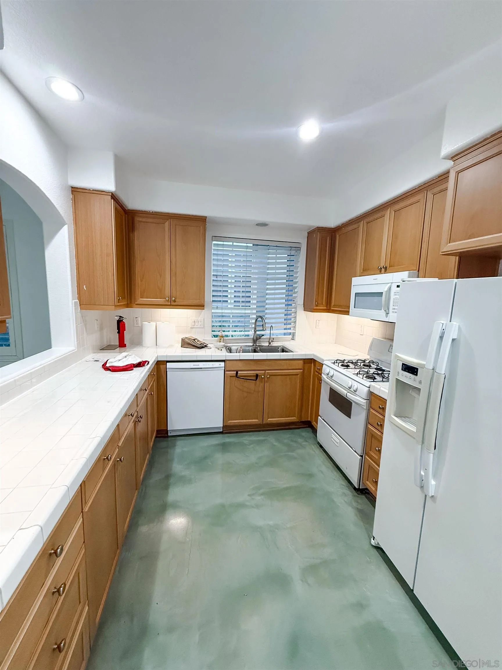 1431 Trouville Lane, Unit 5 Chula Vista, CA 91913 - Photo 8 of 28 a large kitchen with stainless steel appliances sink a microwave and cabinets