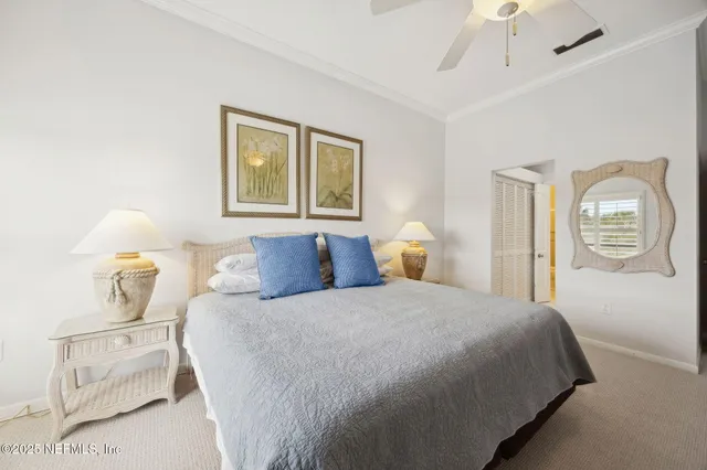 a bedroom with large bed and two windows