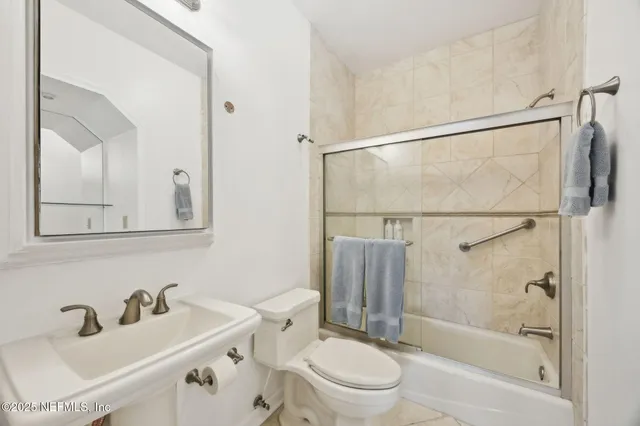 a bathroom with a sink toilet a mirror and shower
