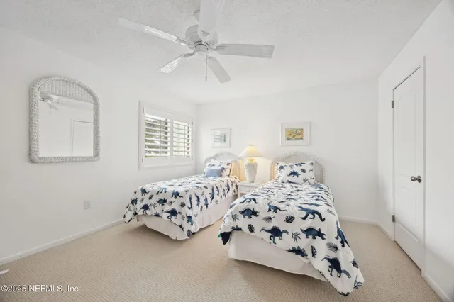 a bedroom with a bed a chandelier and mirror on the dresser