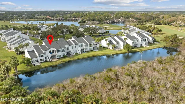 a view of a house with a big yard and palm trees