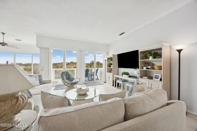 a living room with furniture a flat screen tv and a large window