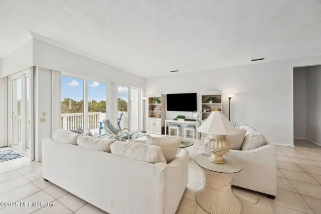 a living room with furniture a flat screen tv and a large window