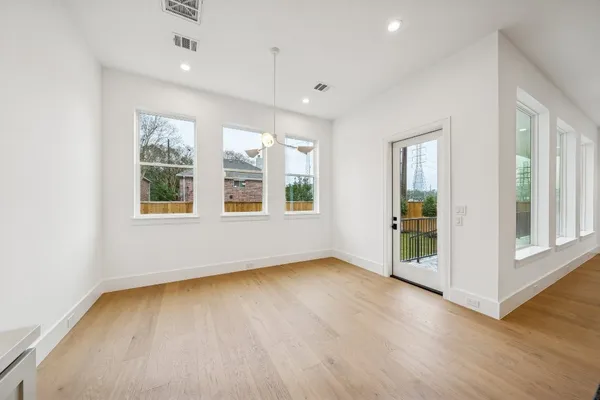 a view of an empty room with wooden floor