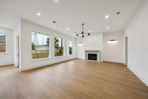 a kitchen with stainless steel appliances granite countertop a stove top oven a sink dishwasher and a fireplace with wooden floor