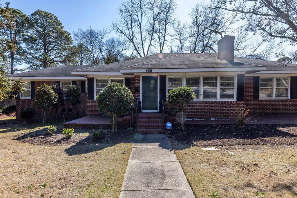 a view of house with yard and outdoor seating
