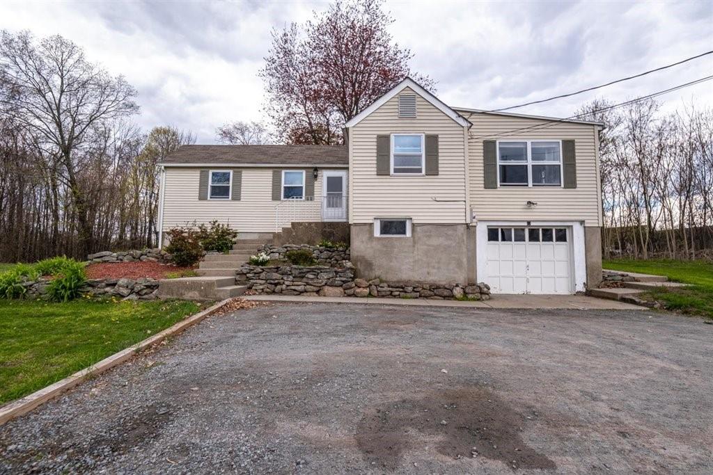 a view of a house with a yard and a large tree