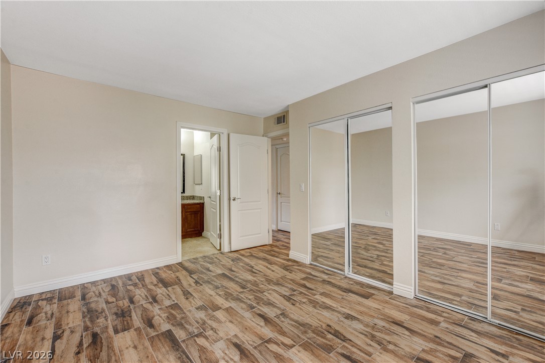 7200 West Pirates Cove Road, Unit 1026 Las Vegas, NV 89145 - Photo 24 of 35 This spacious bedroom features wood-look flooring and convenient mirrored closet doors.