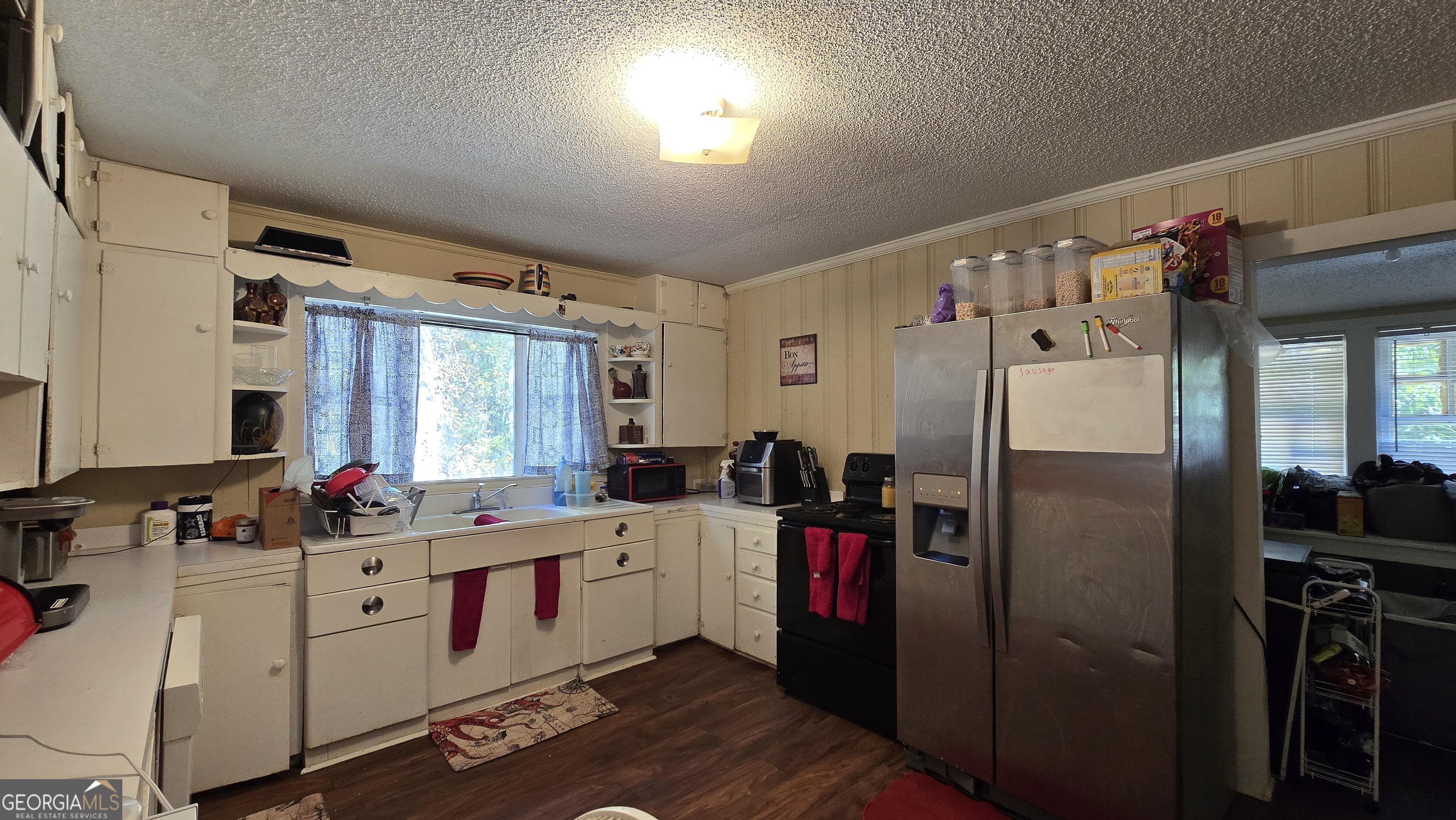 377 Dock Hyde Road Carrollton, GA 30116 - Photo 25 of 32 a kitchen with refrigerator a sink dishwasher a stove and white cabinets with wooden floor