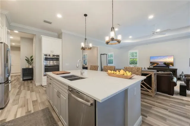 a kitchen with stainless steel appliances granite countertop a sink a stove and a refrigerator