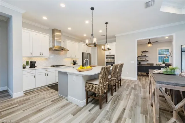 a kitchen with a table chairs stove a sink dishwasher and cabinets with wooden floor